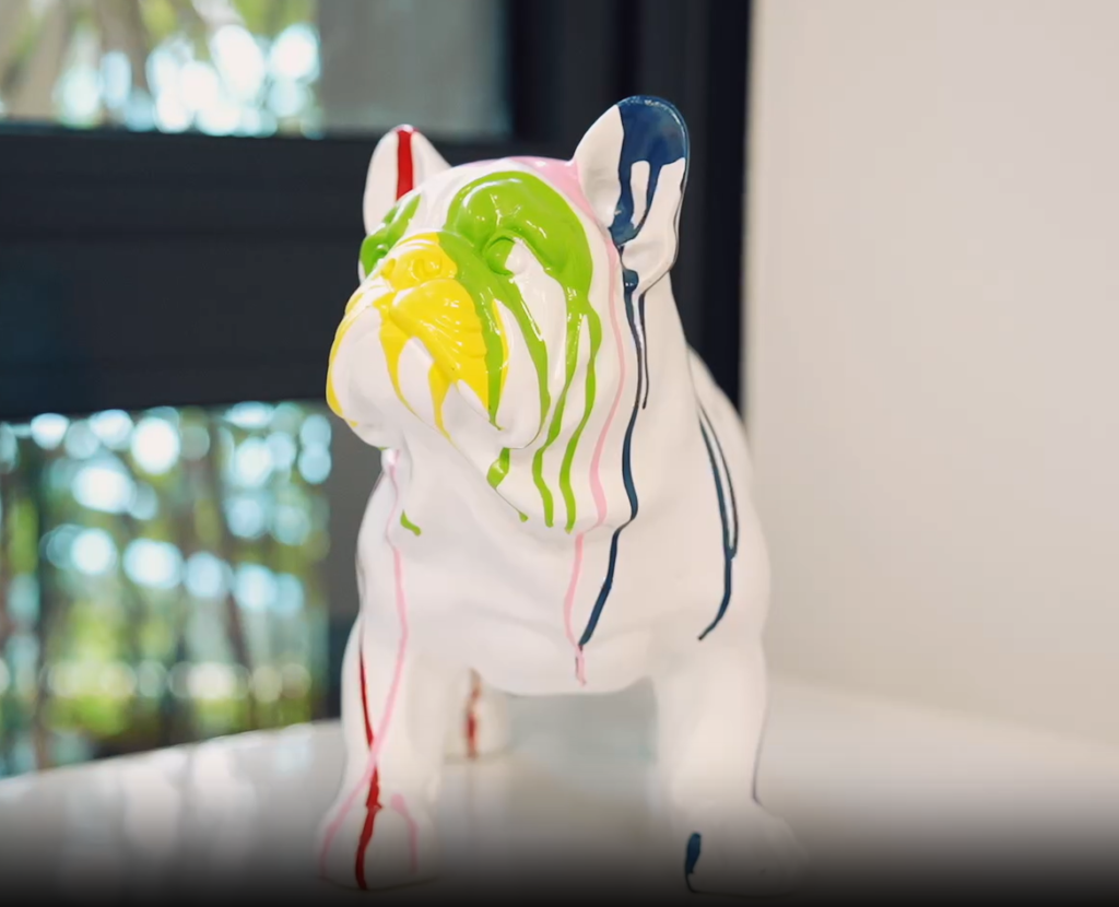 statue de chien blanc recouverte de coulures de peinture colorée